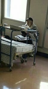 Rav Berland, shlita, sitting up by his hospital bed and learning immediately after the surgery.